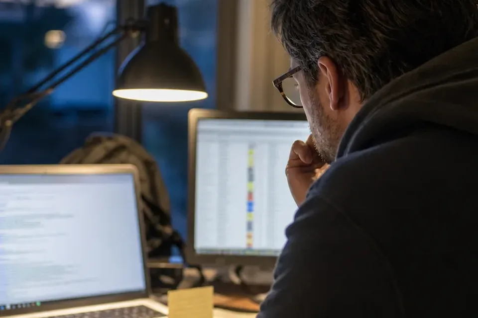 An engineering lead working out the cost of a developer hire at a home office desk