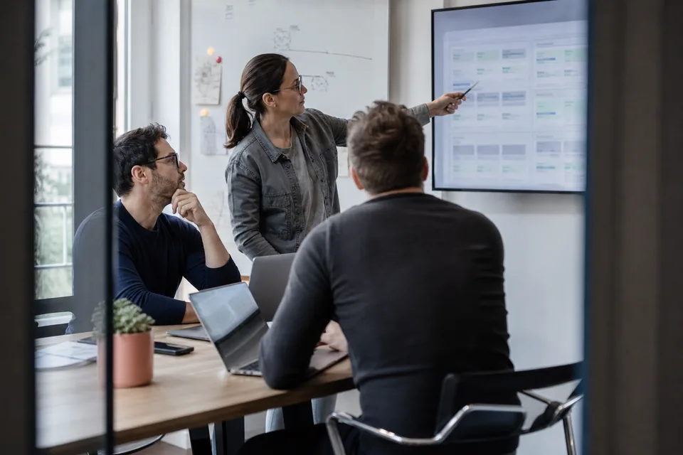 Engineering team reviewing a candidate scorecard on a large monitor